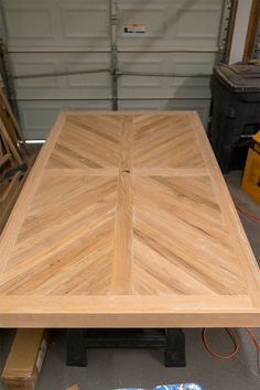 a wooden table sitting on top of a floor next to some boxes and pallets