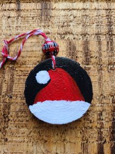 a round ornament with a santa hat on it sitting on a wooden surface