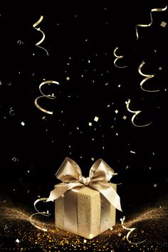 a gold gift box with a bow and streamers in the air, surrounded by confetti