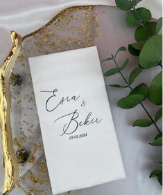 a white towel with the words eva and baki on it next to some green leaves