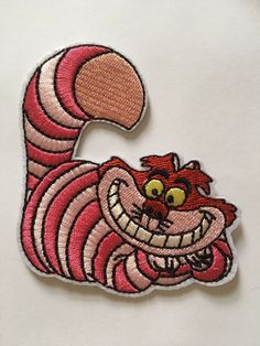 a red and white patch with an image of a smiling cat on it's back