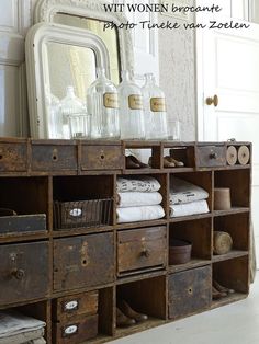 an old dresser with many drawers in front of a mirror