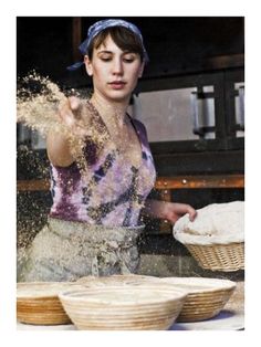 a woman is sprinkling flour on some pies