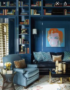 a living room filled with blue furniture and bookshelves