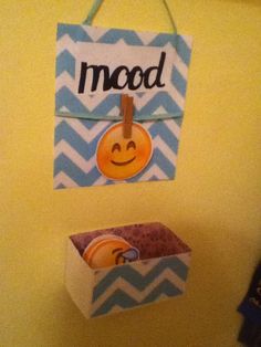 two boxes are hanging on the wall next to a sign that says mood and an emoticive smiley face