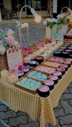 a table topped with lots of cupcakes covered in frosting and toppings