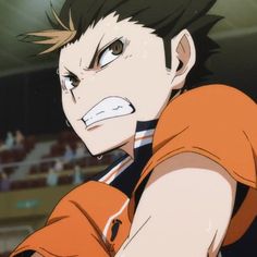 an anime character with black hair and orange shirt looking at the camera in front of a crowd