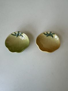 two green and yellow dishes sitting next to each other on a white counter top,