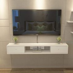 a flat screen tv mounted to the side of a wall next to a white shelf