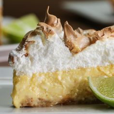 a slice of lime pie on a plate with a wedge of lime next to it