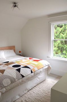 a bed sitting under a window in a bedroom