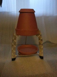 a brown pot sitting on top of a wooden stand