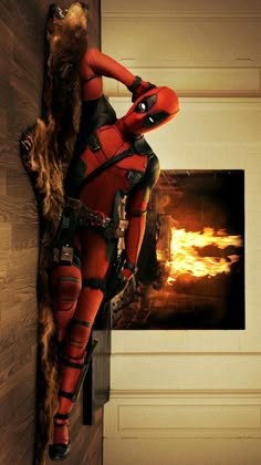 deadpool is hanging on the wall in front of a fire place with his hands behind his head