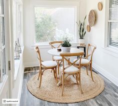 a dining room table with chairs and a potted plant in the corner next to it