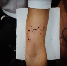 a person with a star tattoo on their arm that has the shape of a zodiac sign