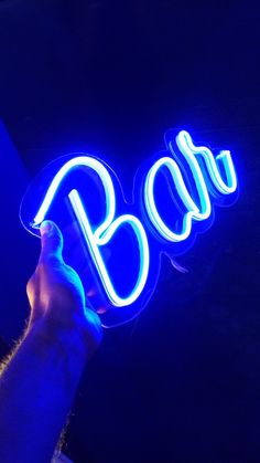 a person holding up a neon sign that says boo