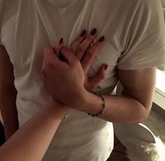 two people standing next to each other with their hands on one another's chest