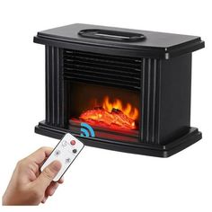 a person holding a remote control in front of an electric fireplace