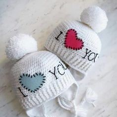 two knitted hats with i love you written on them