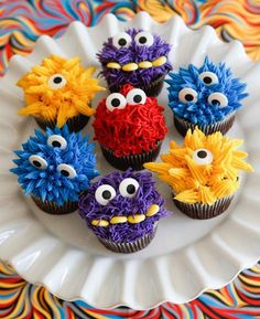 cupcakes decorated to look like monsters on a plate