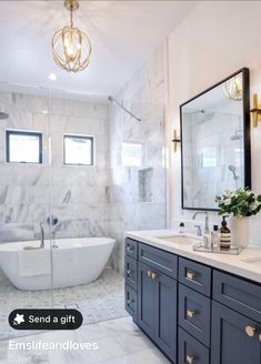 a bathroom with marble counter tops and dark blue cabinets, along with a white bathtub