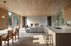 the kitchen and living room are separated by an open floor plan with wood paneling