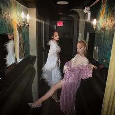 two mannequins dressed in white and pink standing next to each other