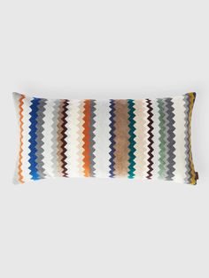 a multicolored striped pillow on a white background