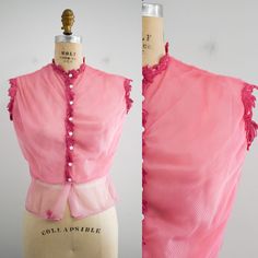 "Description: 1940s/50s pink sheer nylon blouse. It has a diagonal pin tucked design. The neck, button placket, and arm holes have a leafy trim. Sleeveless. Nipped waist. Condition: In fair condition. It has a few tiny holes. It was originally cream, but wouldn't release its dinginess. We dyed it pink. Designer: Sharon Mode  Stated size: n/a  Measurements:  Armpit to armpit: 19\" Armhole circumference: 15\"  Overall length: 18\"  Waist: 27.5\"  ---> If you need an order shipped by a particular date or shipped via a quicker method, please ask PRIOR to purchase to see if we can accommodate that request. Visit the rest of our shop for more goodies ---> https://www.etsy.com/shop/BlackbirdAntiquesNC Visit our shop policies page for sizing info, shipping guidelines, and more ---> https://www.ets Vintage Pink Blouse With Peter Pan Collar, 1940s Peasant Blouse, Vintage Pink Fitted Camisole, Retro Pink Button-up Blouse, Vintage Pink Blouse With Button Closure, Sewing Tape Measure, Pink Sheer, Pin Tucks, Shop Policies