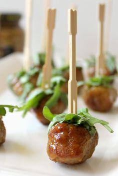 small appetizers with toothpicks are on a white plate and ready to be eaten