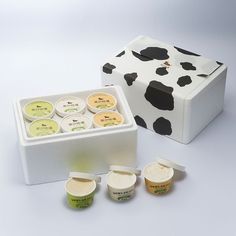 a cow print box with six different creams in it