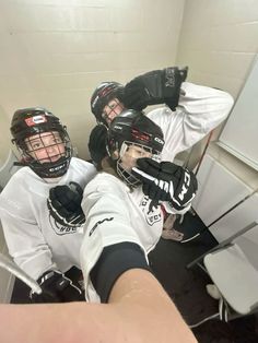 two people wearing helmets and gloves in a room