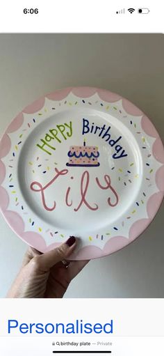 a person holding up a plate with the words happy birthday on it