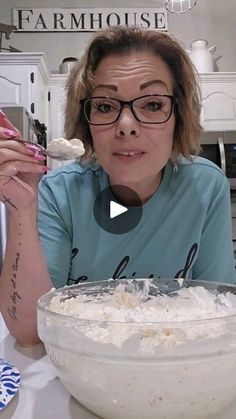 a woman sitting in front of a bowl filled with food