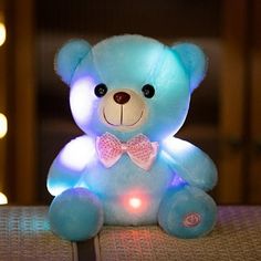 a light up teddy bear sitting on top of a table