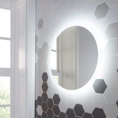 a bathroom with hexagonal tiles and a round mirror