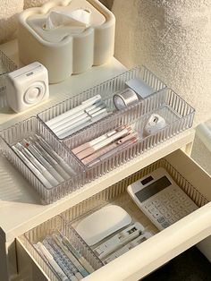 the drawers are organized with various items such as pens, pencils and telephones