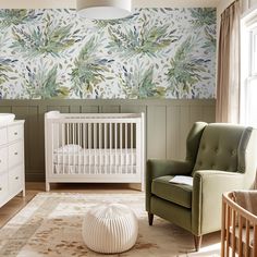 a baby's room with a green chair and white crib in front of a floral wallpaper