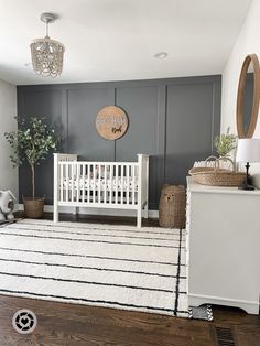 a baby's room with gray walls and white furniture