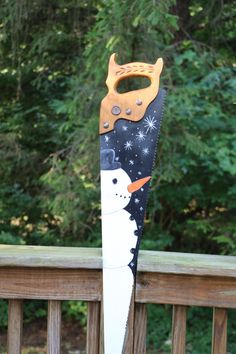 a pair of skis with a snowman design on them sitting on a wooden deck