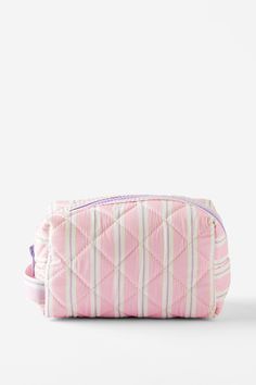 a pink and white quilted bag sitting on top of a table