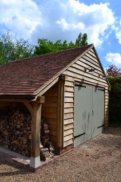 a shed with wood stacked in front of it