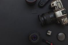 an overhead view of a camera, lens and other items on a black table top