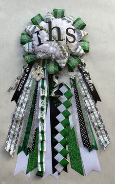 a green and white ribbon with the word ths on it's centerpiece