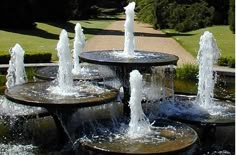 several water fountains in the middle of a park