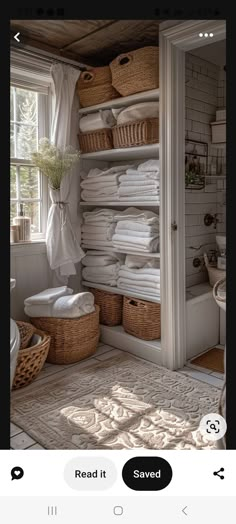 an open closet filled with lots of white linens next to a sink and window