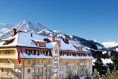 a building with snow covered mountains in the background