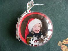 a christmas ornament with a child's photo in it on the floor