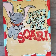 an elephant is on top of a sign that says don't just fly soar