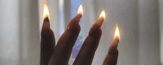 someone holding out their fingers with candles in front of them, as if they were trying to light up the room